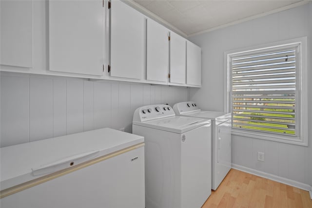 washroom featuring washer and clothes dryer, light wood-type flooring, and cabinets