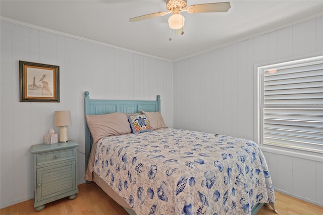 bedroom featuring ceiling fan, light hardwood / wood-style flooring, and ornamental molding