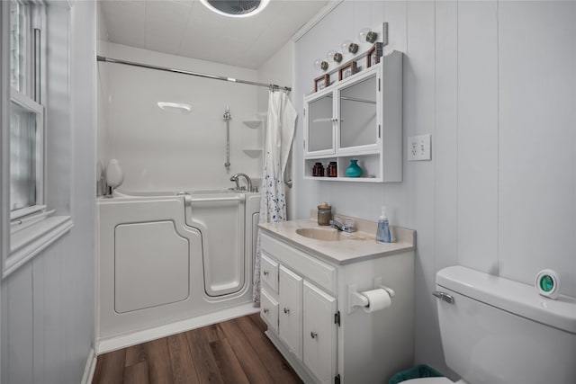 full bathroom with vanity, shower / bathtub combination with curtain, toilet, and hardwood / wood-style floors