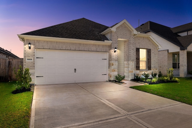 view of front of house with a garage and a yard