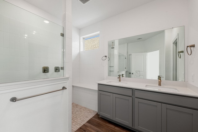 bathroom featuring vanity, hardwood / wood-style floors, and tiled shower