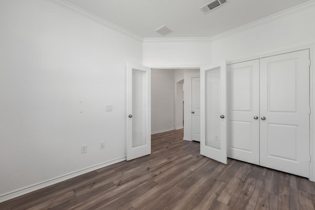 unfurnished bedroom featuring crown molding, dark wood-type flooring, and a closet