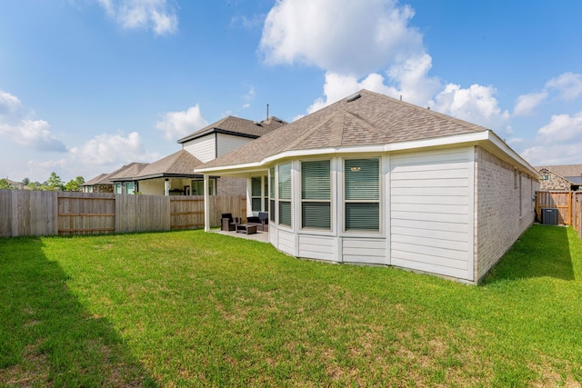 back of house featuring cooling unit, a yard, and a patio