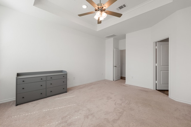 unfurnished bedroom with light carpet, a raised ceiling, and ceiling fan