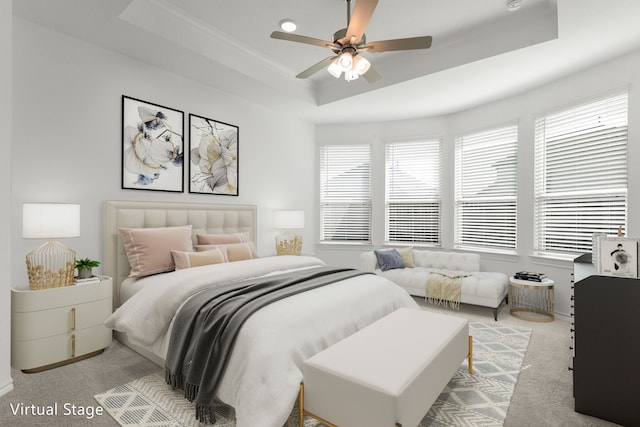 bedroom featuring ceiling fan, light carpet, and a tray ceiling