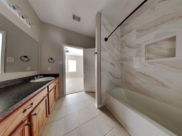 bathroom with tile patterned floors, vanity, and tiled shower / bath