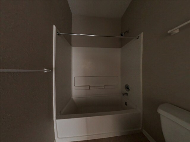 bathroom with tub / shower combination and toilet