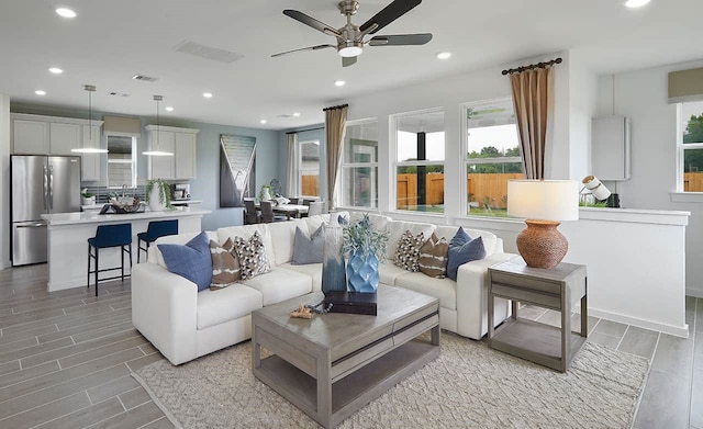 living room featuring light hardwood / wood-style flooring and ceiling fan