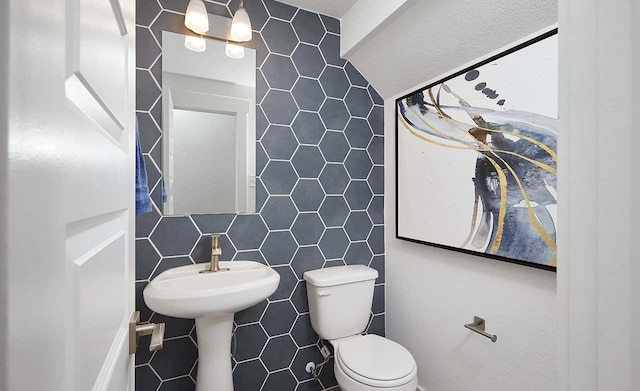 bathroom featuring tile walls and toilet