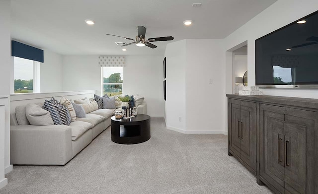 living room featuring light carpet, a wealth of natural light, and ceiling fan