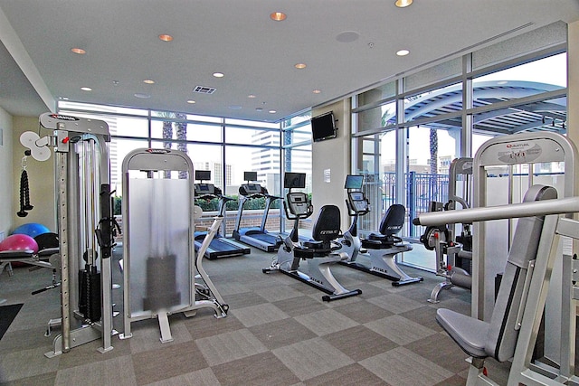 exercise room with a healthy amount of sunlight, expansive windows, and visible vents