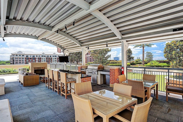 view of patio / terrace featuring an outdoor kitchen, outdoor wet bar, outdoor dining area, and area for grilling