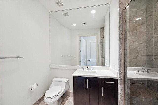 bathroom featuring vanity, toilet, and a shower with shower door