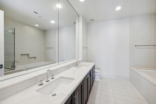 bathroom with a garden tub, a sink, and tile patterned floors