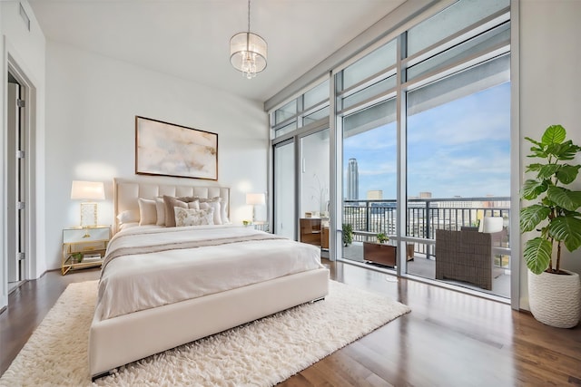 bedroom featuring hardwood / wood-style floors, floor to ceiling windows, access to outside, and a chandelier