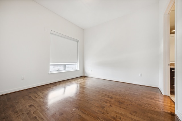 unfurnished room with dark hardwood / wood-style flooring