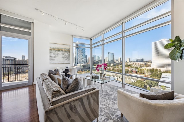 sunroom / solarium featuring rail lighting and a view of city