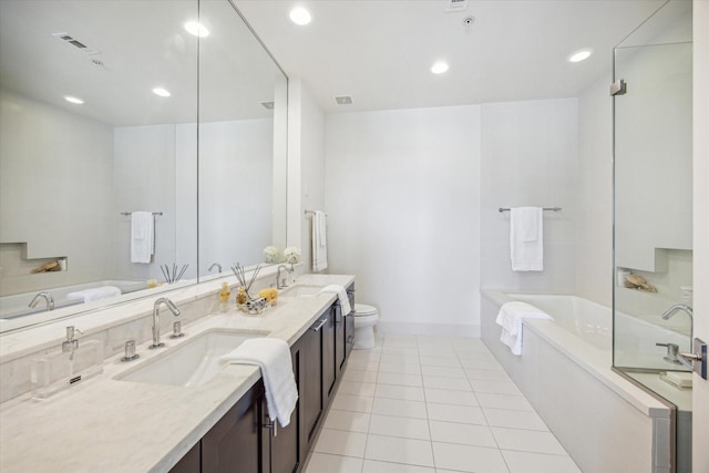 bathroom with a garden tub, a sink, and tile patterned floors