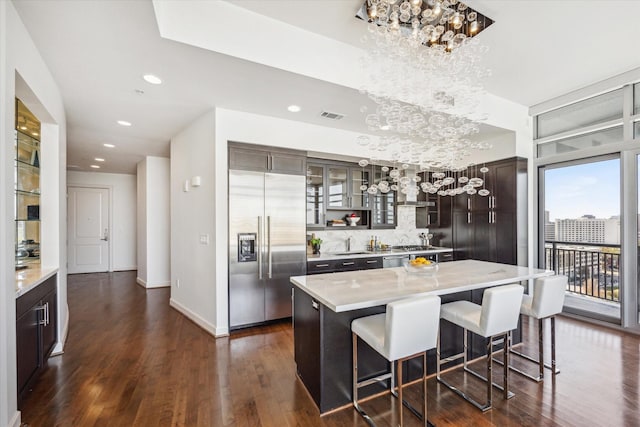 kitchen featuring dark wood-style floors, light countertops, stainless steel built in refrigerator, and visible vents