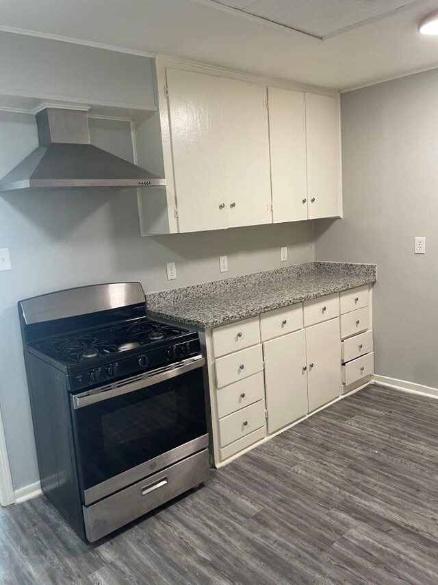 kitchen featuring wall chimney range hood, dark hardwood / wood-style flooring, gas stove, and white cabinetry