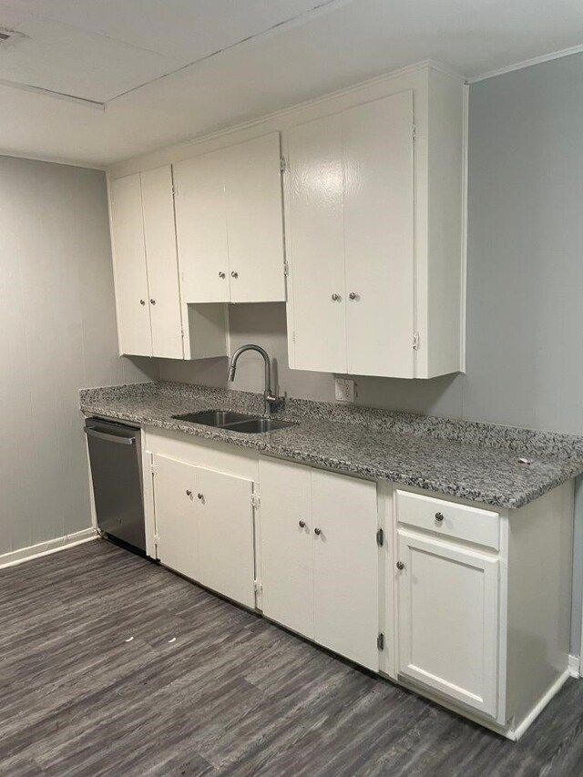 kitchen featuring sink, stainless steel dishwasher, dark wood-type flooring, dark stone countertops, and white cabinets