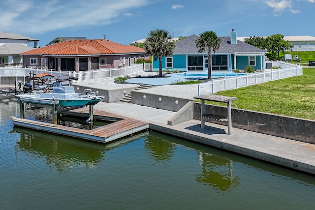 dock area with a water view, a fenced in pool, and a yard