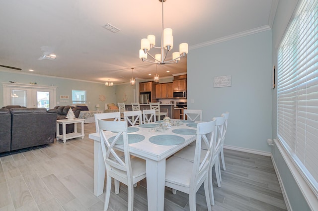 dining space with baseboards, a notable chandelier, visible vents, and crown molding