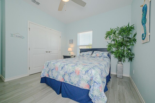 bedroom featuring ceiling fan, a closet, and light hardwood / wood-style floors