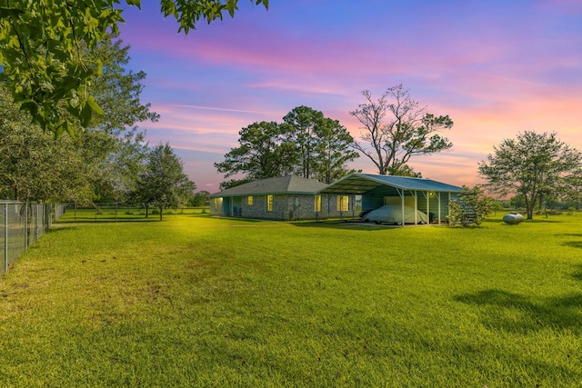 yard at dusk featuring a carport