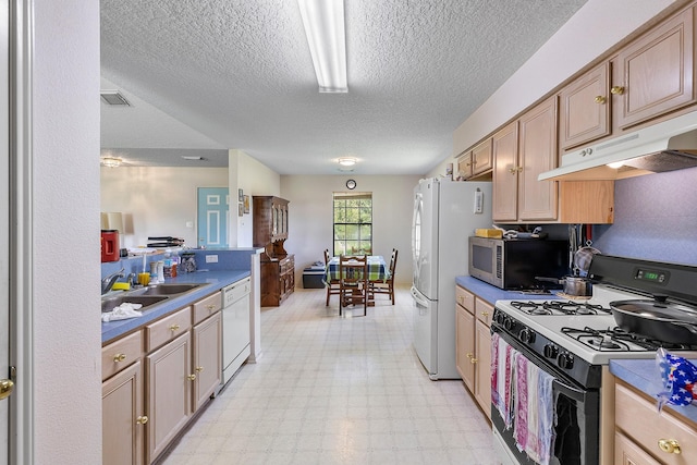 kitchen with white appliances, sink, and a textured ceiling