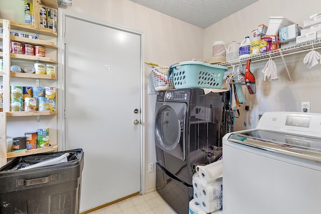 laundry room with washing machine and dryer and a textured ceiling