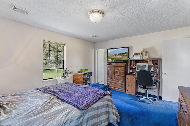 bedroom featuring a textured ceiling and dark colored carpet