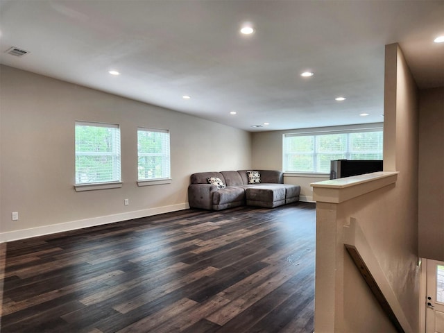 living area with dark wood-type flooring, recessed lighting, visible vents, and baseboards