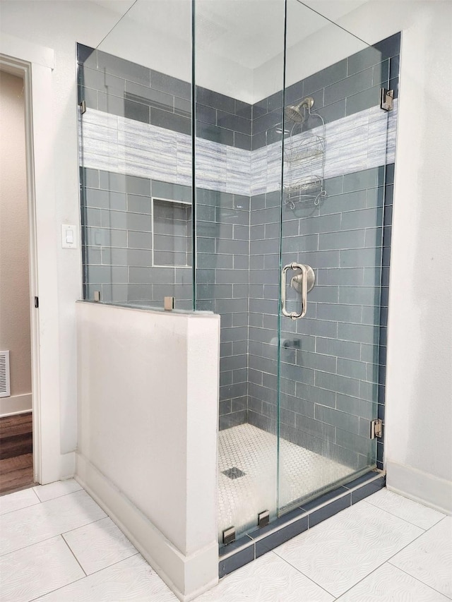 bathroom featuring baseboards, a shower stall, visible vents, and tile patterned floors