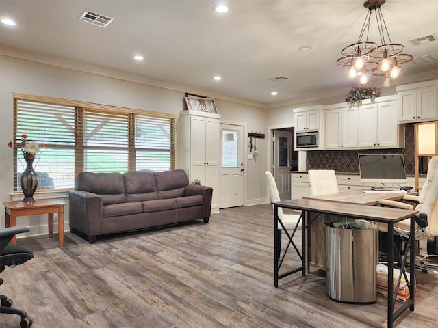 kitchen with visible vents, stainless steel microwave, backsplash, and wood finished floors