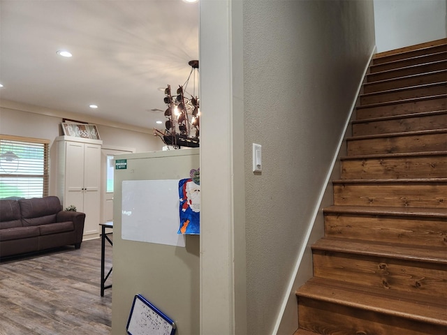 stairs with a textured wall, baseboards, wood finished floors, and recessed lighting