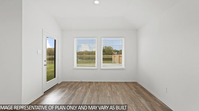 unfurnished room with wood-type flooring and lofted ceiling