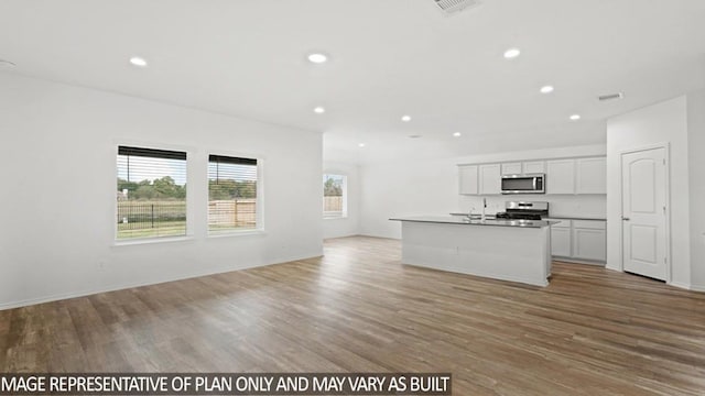 kitchen featuring stainless steel appliances, a kitchen island with sink, sink, light hardwood / wood-style flooring, and white cabinets