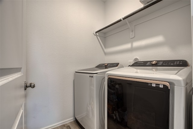 laundry area featuring washer and dryer and light hardwood / wood-style flooring