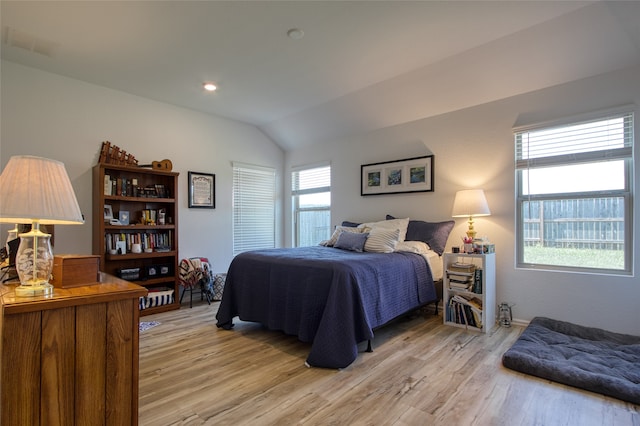 bedroom featuring lofted ceiling and light hardwood / wood-style floors