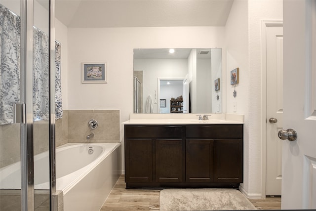 bathroom featuring shower with separate bathtub, vanity, and hardwood / wood-style floors