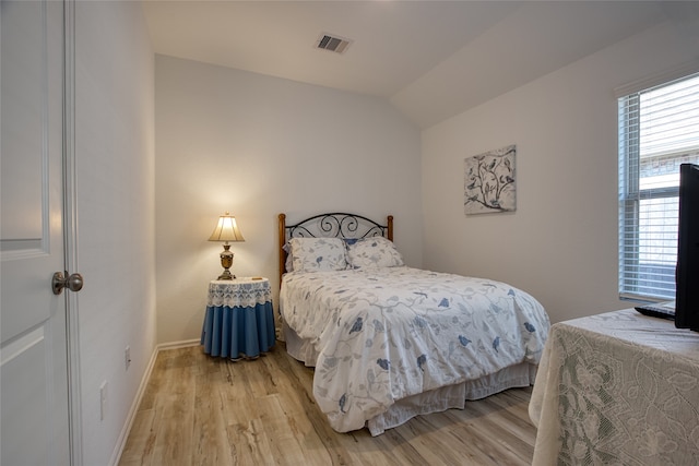 bedroom featuring light hardwood / wood-style flooring and lofted ceiling