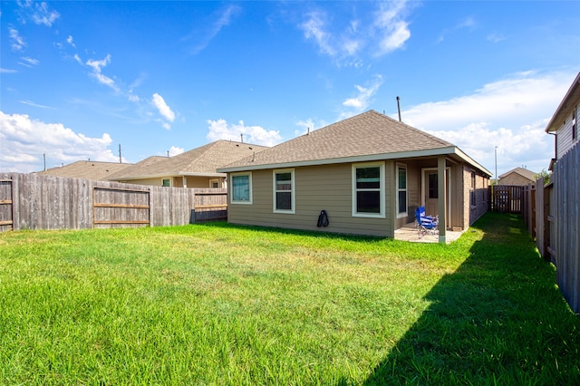 rear view of house featuring a yard