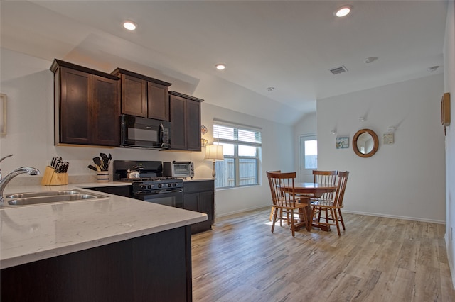 kitchen featuring light stone counters, black appliances, dark brown cabinetry, light hardwood / wood-style floors, and sink