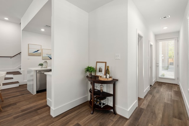 corridor featuring stairway, baseboards, visible vents, and dark wood-type flooring