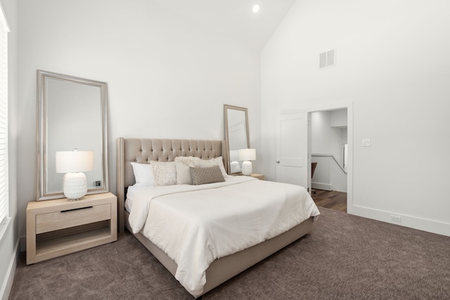 carpeted bedroom with high vaulted ceiling, baseboards, and visible vents