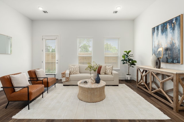 living area featuring visible vents, baseboards, and wood finished floors