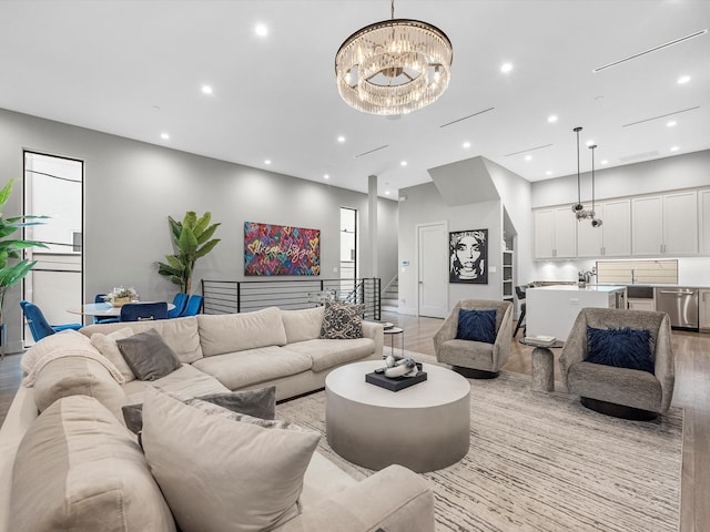 living room with an inviting chandelier and light hardwood / wood-style floors