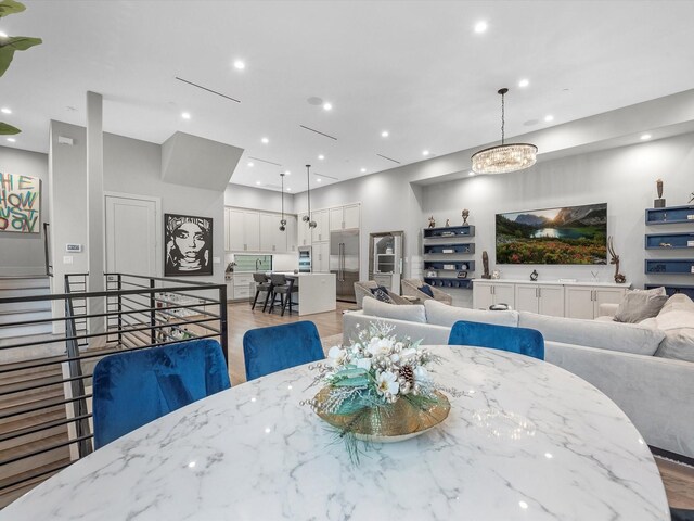 dining space featuring light hardwood / wood-style flooring and a chandelier