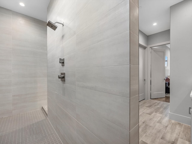 bathroom featuring hardwood / wood-style floors and tiled shower